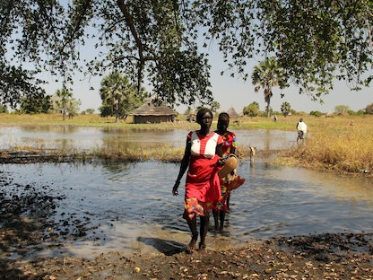 امرأة نازحة تعبر منطقة غمرتها المياه في قرية مدير أجاك جنوب السودان - 27 نوفمبر 2020 - REUTERS