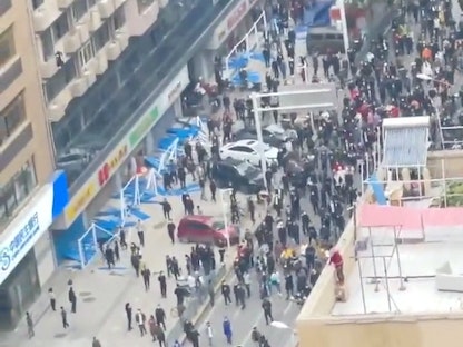 سكان خلال مسيرة احتجاجة على القيود المفروضة لمكافحة كورونا في ووهان بمقاطعة هوبي وسط الصين- 27 نوفمبر 2022 - REUTERS