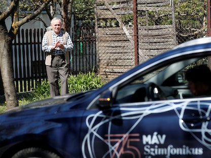رجل مسن يستمتع إلى تسجيلات الموسيقى الكلاسيكية على مكبرات الصوت لسيارة تتجول في أنحاء المدينة - REUTERS