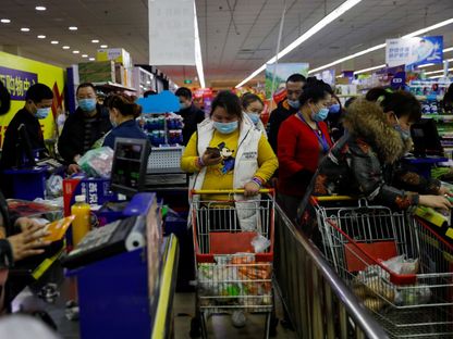 صينيون يتسوقون بأحد المراكز التجارية في بكين. 10 فبراير 2021 - Reuters