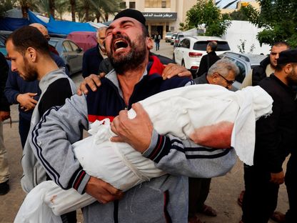 رجل فلسطيني يحمل جثمان طفلة من أفراد عائلته قتلتها غارة إسرائيلية في خان يونس بجنوب قطاع غزة. 22 نوفمبر 2023 - Reuters