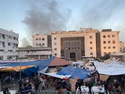 أعمدة دخان تتصاعد خلف مبنى الجراحات التخصصي التابع لمستشفى الشفاء بمدينة غزة. 8 نوفمبر 2023 - Reuters