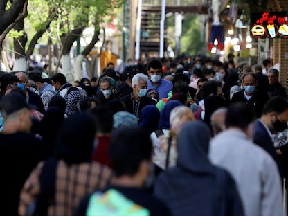 إيرانيون يرتدون كمامات واقية في منطقة مزدحمة في العاصمة طهران، 30 مارس 2021 - VIA REUTERS