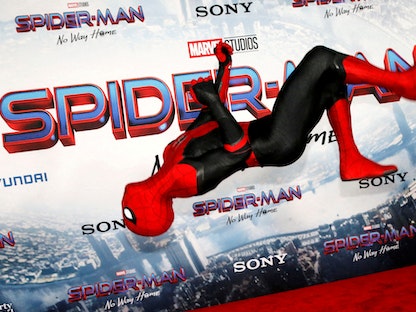 شخص يرتدي زي الرجل العنكبوت يؤدي حركات استعراضية خلال العرض الأول لفيلم "سبايدر مان نو واي هوم" - REUTERS