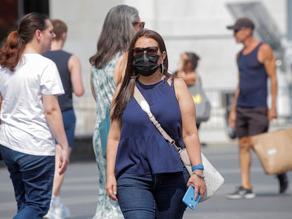 امرأة ترتدي قناعاً في واشنطن سكوير بارك في مدينة نيويورك. 22 يوليو 2021 - REUTERS