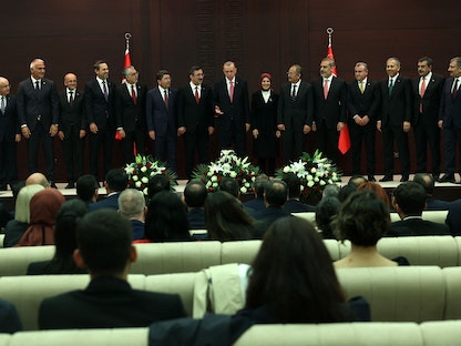 الرئيس التركي رجب طيب أردوغان وسط أعضاء حكومته الجديدة، أثناء أداء اليمين الدستورية في البرلمان- 3 يونيو 2023 - AFP