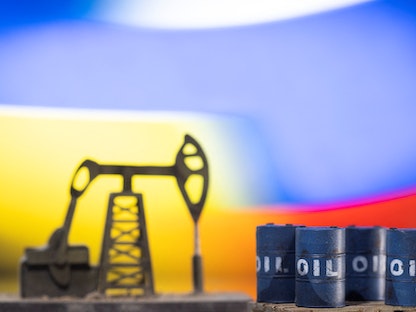نموذج توضيحي لبراميل النفط ، ورافعة ضخ ، مع ألوان العلم الأوكراني والروسي. - REUTERS