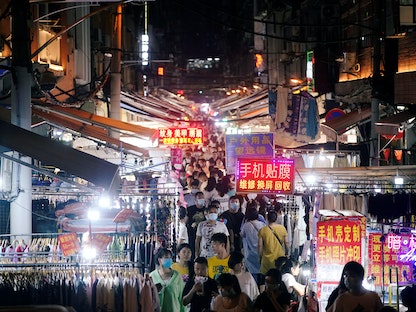 صينيون في أحد شوارع مدينة ووهان التابعة لمقاطعة هوبي - REUTERS