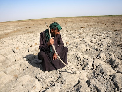 عراقي يتفقد جفاف أحد المستنقعات بمحافظة ذي قار نتيجة شح المياه - 3 يونيو 2022 - REUTERS