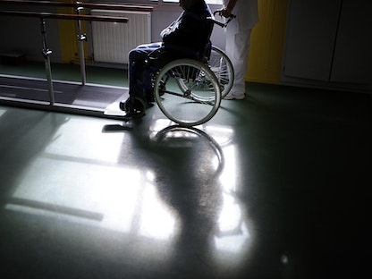 مصاب بالشلل على كرسي متحرك - AFP