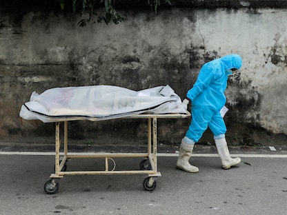عامل طبي ينقل أحد ضحايا متحور دلتا من فيروس كورونا في سيريلانكا، 6 أغسطس 2021 - REUTERS