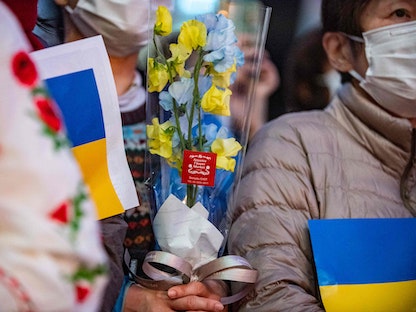 أشخاص يشاركون في حفل موسيقي خاص في الهواء الطلق بعنوان "الحب ضد الحروب" لدعم أوكرانيا، في منطقة إكيبوكورو بالعاصمة اليابانية طوكيو - 11 مارس 2022  - AFP
