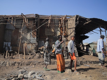 سكان ومسلحون يقفون بجوار منازل دمرتها غارة جوية أثناء القتال بين قوات الدفاع الوطني الإثيوبية (ENDF) وقوات جبهة تحرير شعب تيجراي في بلدة كاساجيتا. 25 فبراير 2022 - REUTERS