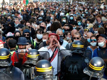 متظاهر يقف بمواجهة الشرطة في باريس ويهتف بشعارات مناهضة للحكومة - 12 سبتمبر 2020 - AFP