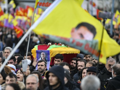 أكراد يحملون نعشاً ملفوفاً بالعلم لأحد ضحايا إطلاق النار في شارع إنجين خلال جنازة، في ضاحية فيلير لو بيل شمال باريس، فرنسا- 3 يناير 2023 - AFP