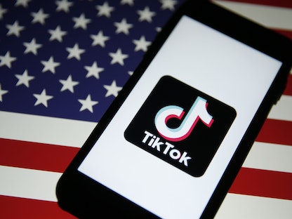شعار تطبيق "تيك توك" على خلفية علم أميركي، 3 أغسطس 2020 - Bloomberg