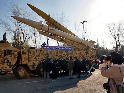 إيرانيون يشاهدون عرضاً عسكرياً للصواريخ الباليستية في العاصمة طهران - 7 يناير 2022 - AFP
