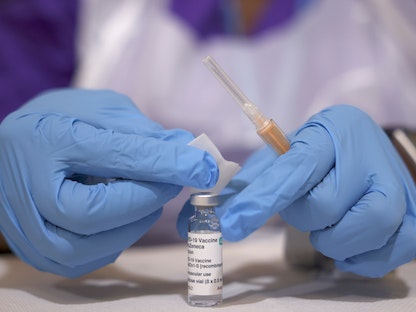 عامل طبي يحضر جرعة من لقاح كورونا في أحد مراكز التطعيم بالعاصمة البريطانية لندن، 28 مارس 2021 - REUTERS