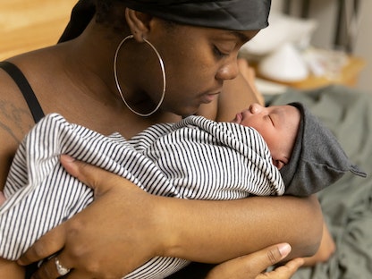 سيّدة أميركية تعمل مساعدة طبية تحمل طفلها بعد ساعات من ولادته في نيويورك. 8 فبراير 2023 - REUTERS