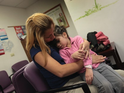 طفلة تعاني من آلام في المعدة داخل عيادة في مدينة أورورا بولاية كولورادو الأميركية- 28 يوليو 2009  - Getty Images via AFP