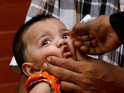 طفلة باكستانية تتلقى لقاح شلل الأطفال في حي منخفض الدخل في كراتشي - 20 يوليو 2020 - REUTERS