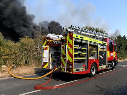 شاحنة إطفاء متوقفة بالقرب من حريق اشتعل في رينهام شرق العاصمة البريطانية لندن - 19 يوليو 2022 - REUTERS