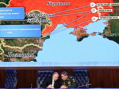 الرئيس الروسي فلاديمير بوتين يستمع إلى رئيس أركان القوات المسلحة فاليري جيراسيموف أمام شاشة ضخمة تظهر خريطة أوكرانيا خلال الاجتماع السنوي لمجلس وزارة الدفاع في موسكو- 21 ديسمبر 2021 - AFP