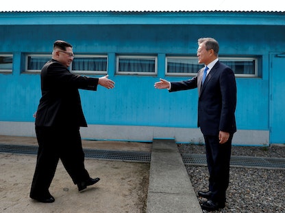 الرئيس الكوري الجنوبي مون جاي إن، والزعيم الكوري الشمالي كيم جونغ أون، يتصافحان داخل المنطقة المنزوعة السلاح التي تفصل الكوريتين- 27 أبريل 2018 - REUTERS