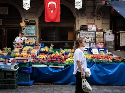 امرأة تقف أمام كشك للفواكه والخضروات في إسطنبول - 21 يوليو 2020 - Bloomberg