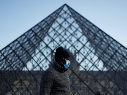 رجل يرتدي قناعاً طبياً للوقاية من كورونا في متحف اللوفر بباريس - 19 فبراير 2022 - REUTERS