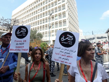 متظاهرون يرفعون لافتات خلال مظاهرة نظمتها مجموعة "صرخة المودعين" بالقرب من مبنى البنك المركزي اللبناني في بيروت، لبنان. 5 أكتوبر 2022. - REUTERS