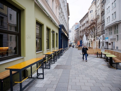 شخص يسير على طول طاولات مهجورة في مطعم مغلق حيث فرضت الحكومة النمساوية الإغلاق الرابع بسبب كورونا في فيينا، النمسا - 22 نوفمبر 2021 - REUTERS