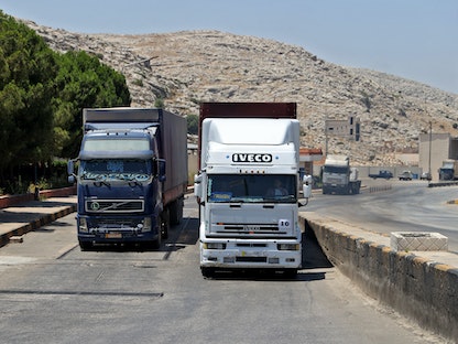 شاحنات تحمل المساعدات الأممية خلال عبورها معبر باب الهوى بين سوريا وتركيا - 8 يوليو 2022 - AFP