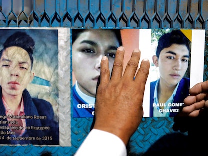 أحد أقارب الأشخاص المفقودين يضع صوراً لأحبائه، حيث يطالب الأقارب ببناء نصب تذكاري مخصص لجميع الأشخاص الذين فقدوا في البلاد، في مكسيكو سيتي، المكسيك - 15 مايو 2022 - REUTERS
