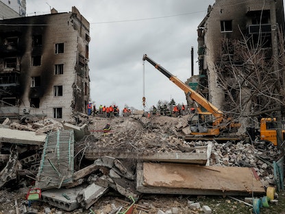 فرق الدفاع المدني تبحث عن ضحايا بين أنقاض أحد المباني السكنية التي دمرها القصف الروسي في مدينة بوروديانكا قرب العاصمة الأوكرانية كييف - 8 أبريل 2022 - REUTERS