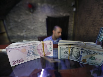 الليرة التركية جنباً إلى الدولار الأميركي في صرافة بمدينة أعزاز التركية. - REUTERS