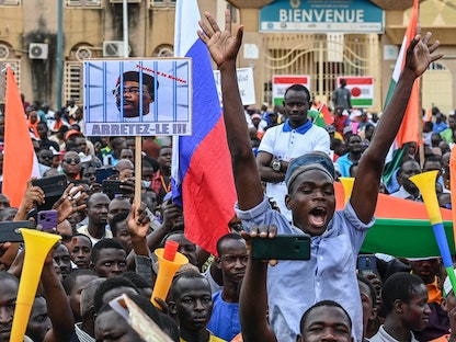 أنصار المجلس العسكري في النيجر يحملون لافتات أثناء تجمع في العاصمة نيامي. 20 أغسطس 2023 - AFP