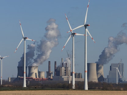 توربينات لتوليد طاقة الرياح أمام محطات لتوليد الطاقة بالفحم البني في مدينة كولن الألمانية - 18 مارس 2022 - REUTERS