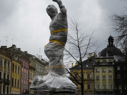 أحد التماثيل المغلّفة في وسط مدينة لفيف في أوكرانيا خشية القصف الروسي- 5 مارس 2022 - AFP