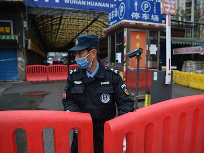 ضابط شرطة يقف عند حاجز نُصب قرب سوق هوانان في ووهان بعد إغلاقه إثر اكتشاف فيروس كورونا للمرة الأولى، 24 يناير 2020  - AFP