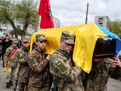 جنود أوكرانيون خلال جنازة زميل لهم لقي حتفه خلال قصف روسي بالقرب من كرفي ريه في أوكرانيا- 29 أبريل 2022 - REUTERS
