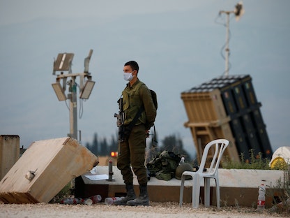 جندي إسرائيلي يقف بجانب نظام القبة الحديدية المضاد للصواريخ بالقرب من الحدود الشمالية لإسرائيل مع لبنان- 27 يوليو 2020 - REUTERS