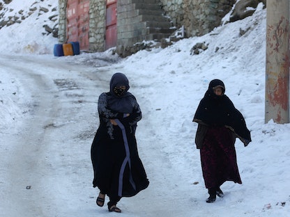 سيدتان تسيران في شارع مغطى بالثلوج في العاصمة الأفغانية كابول. 25 يناير 2023 - REUTERS