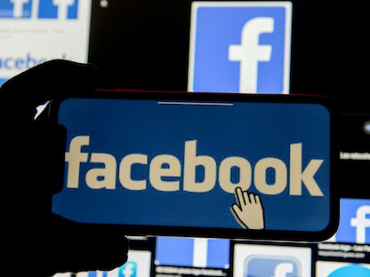 علامة فيسبوك التجارية على شاشة هاتف ذكي وحاسوب شخصي - REUTERS