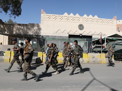 مقاتلون حوثيون يمرون أمام بوابة السفارة الأميركية المغلقة في صنعاء، 18 يناير 2021 - REUTERS