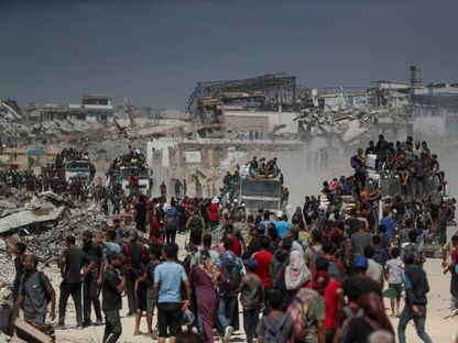 فلسطينيون يعتلون شاحنات بحثاً عن إمدادات المساعدات التي دخلت غزة في بيت لاهيا شمال القطاع. 1 أغسطس 2025 - Reuters