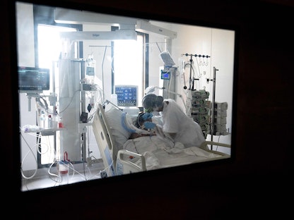 ممرضة تساعد مريضاً مصاباً بفيروس كورونا في وحدة العناية المكثفة بمستشفى جامعة بيير زوبدا-كويتمان (CHU) في فورت دي فرانس بجزيرة مارتينيك الكاريبية الفرنسية-29 أغسطس 2021 - AFP