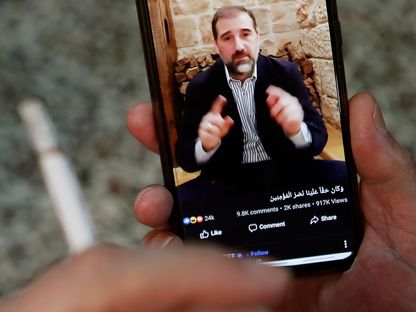 رجل يشاهد مقطع فيديو نشره رجل الأعمال السوري رامي مخلوف على "فيسبوك" - AFP