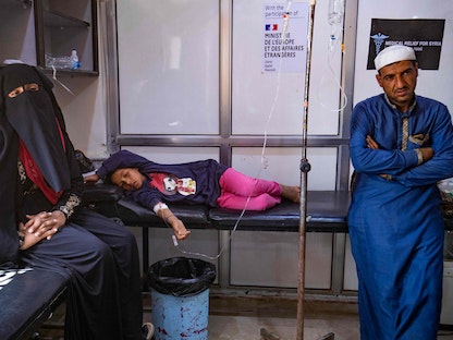 طفلة تتلقى العلاج من وباء الكوليرا بينما يجلس والديها إلى جانبها في مستشفى بمحافظة دير الزور، شرقي سوريا، 17 سبتمبر 2022. - AFP