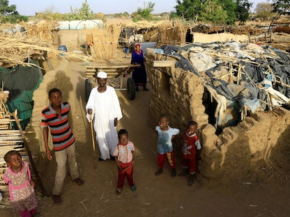 أسرة سودانية نازحة تقف خارج مأواها المؤقت داخل مخيم كلمة للنازحين داخلياً في دارفور - 26 أبريل 2019 - REUTERS